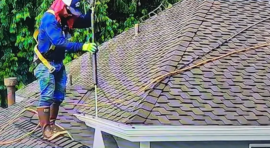 employee on roof pressure washing